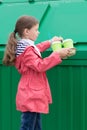 Girl came to throw paper glasses in the trash tank Royalty Free Stock Photo