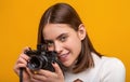 Girl with a cameras. Woman holding camera over yellow background. Girl using a camera photo. Photographing girl make Royalty Free Stock Photo