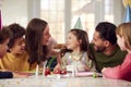 Girl With Candles On Birthday Cake At Surprise Party With Parents And Friends At Home Royalty Free Stock Photo