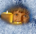 Girl with candles looking through a frosted window Royalty Free Stock Photo