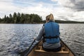 Girl canoeing with Canoe on the lake of two rivers in the algonquin national park in Ontario Canada on sunny cloudy day Royalty Free Stock Photo