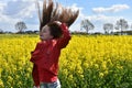 Girl in canola field with wild flying hair Royalty Free Stock Photo