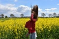 Girl in canola field with wild flying hair Royalty Free Stock Photo