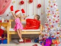 Girl in a cap and mittens of Santa Claus surprised that a girl got out of the bag Royalty Free Stock Photo