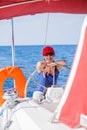 Girl captain on board of sailing yacht on summer cruise. Travel adventure, yachting with child on family vacation. Royalty Free Stock Photo