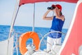 Girl captain on board of sailing yacht on summer cruise. Travel adventure, yachting with child on family vacation. Royalty Free Stock Photo