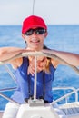 Girl captain on board of sailing yacht on summer cruise. Travel adventure, yachting with child on family vacation. Royalty Free Stock Photo