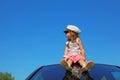 Girl with captain cap sitting on car roof Royalty Free Stock Photo