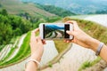 Girl capturing rice terrace scenery with a phone