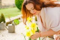 Girl cares for flowers in garden in country house