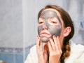 Girl cares for oily skin. Cosmetic procedures. Skin care. Young woman with a black mud mask on her face. cleansing pores. Cosmetic Royalty Free Stock Photo