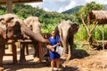 Girl caress three elephants at sanctuary in Chiang Mai Thailand