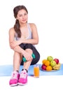 Girl on the carpet with dumbbell and fruit