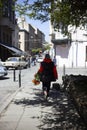 The girl carries a bouquet of orange lilies on the street of the old town