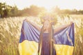 Girl carries fluttering blue and yellow flag of Ukraine in field Royalty Free Stock Photo