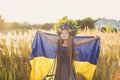 Girl carries fluttering blue and yellow flag of Ukraine in field Royalty Free Stock Photo