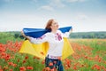 Girl carries fluttering blue and yellow flag of Ukraine in field Royalty Free Stock Photo