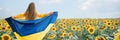 Girl carries fluttering blue and yellow flag of Ukraine in sunflower field. Royalty Free Stock Photo