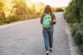 The girl is carrying a backpack on her shoulders, from which her dog looks out. A girl and her pet travel together. Back view Royalty Free Stock Photo