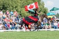 Girl carrying a Canadian flag performs on a horse at the RCMP Musical Ride