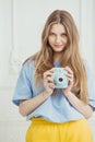 Girl in casual cloth stands with video camera in hand. Royalty Free Stock Photo