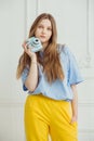 Girl in casual cloth stands with video camera in hand. Royalty Free Stock Photo