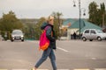 A girl in casual clothes crosses the road through a pedestrian crossing Royalty Free Stock Photo