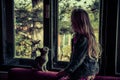 Girl and cat behind the window Royalty Free Stock Photo