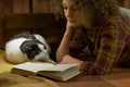 Girl and a cat reading an open book