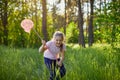 A girl catches butterflies with a pink juice on a summer day Royalty Free Stock Photo