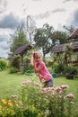 Girl catches butterfly in village garden at summer, young bug-hunter, happy vacation in countryside Royalty Free Stock Photo