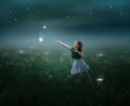 The girl catches stars in the sap at night and puts them in a bucket in the field. Royalty Free Stock Photo