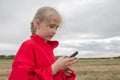 Girl with cell phone and cloudy sky Royalty Free Stock Photo