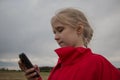 Girl with cell phone and cloudy sky Royalty Free Stock Photo