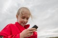 Girl with cell phone and cloudy sky Royalty Free Stock Photo