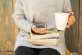 Girl with cell phone, cup of coffee and books Royalty Free Stock Photo