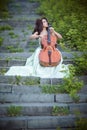 Girl with a cello on the stairs