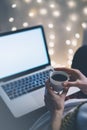 Girl in a chair in a homely atmosphere with an open laptop with a empty blank screen monitor and a cup of coffee or tea