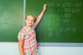 Girl with chalk writing mathematics equation