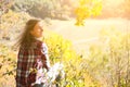 Girl in the checkered shirt is sitting in the autumn forest. Seasonal concept. Stylish hipster clothes outdoors. Nature philosophy Royalty Free Stock Photo