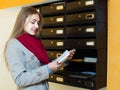 Girl checking correspondence at lobby Royalty Free Stock Photo