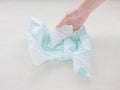 The girl checks the absorbency of a baby nappy with a napkin, close-up