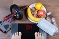 Girl checks her weight after quarantine. Concept of healthy lifestyle during self-isolation