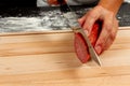 Girl chef cuts salami sausage for making italian pizza on a wooden cutting board Royalty Free Stock Photo