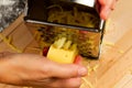 Girl chef rubs fresh fragrant cheese on a grater for making italian pizza on a wooden cutting board