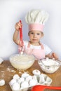 A girl in a chef's hat prepares the dough, in her hands a whisk Royalty Free Stock Photo