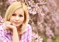 Girl with Cherry Blossom. Beautiful Blonde Young Woman