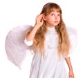 Girl child in angel costume listen, hand near ear. Royalty Free Stock Photo