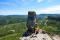 A girl with a child on the background of a view of the Crimean mountains from the cave city of Tepe-Kermen. Crimea.