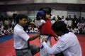 A girl child is being helped to get prepare herself for the next round of karate fight.